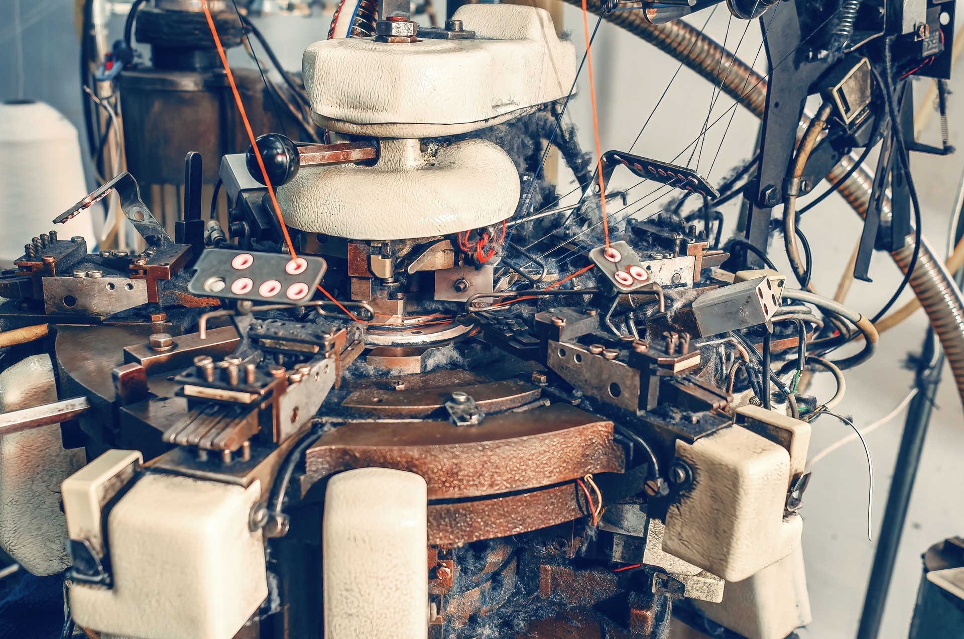 Rear view of knitting machine with cotton yarn in sock factory. Knitting machine with dust from yarn. Production background.
