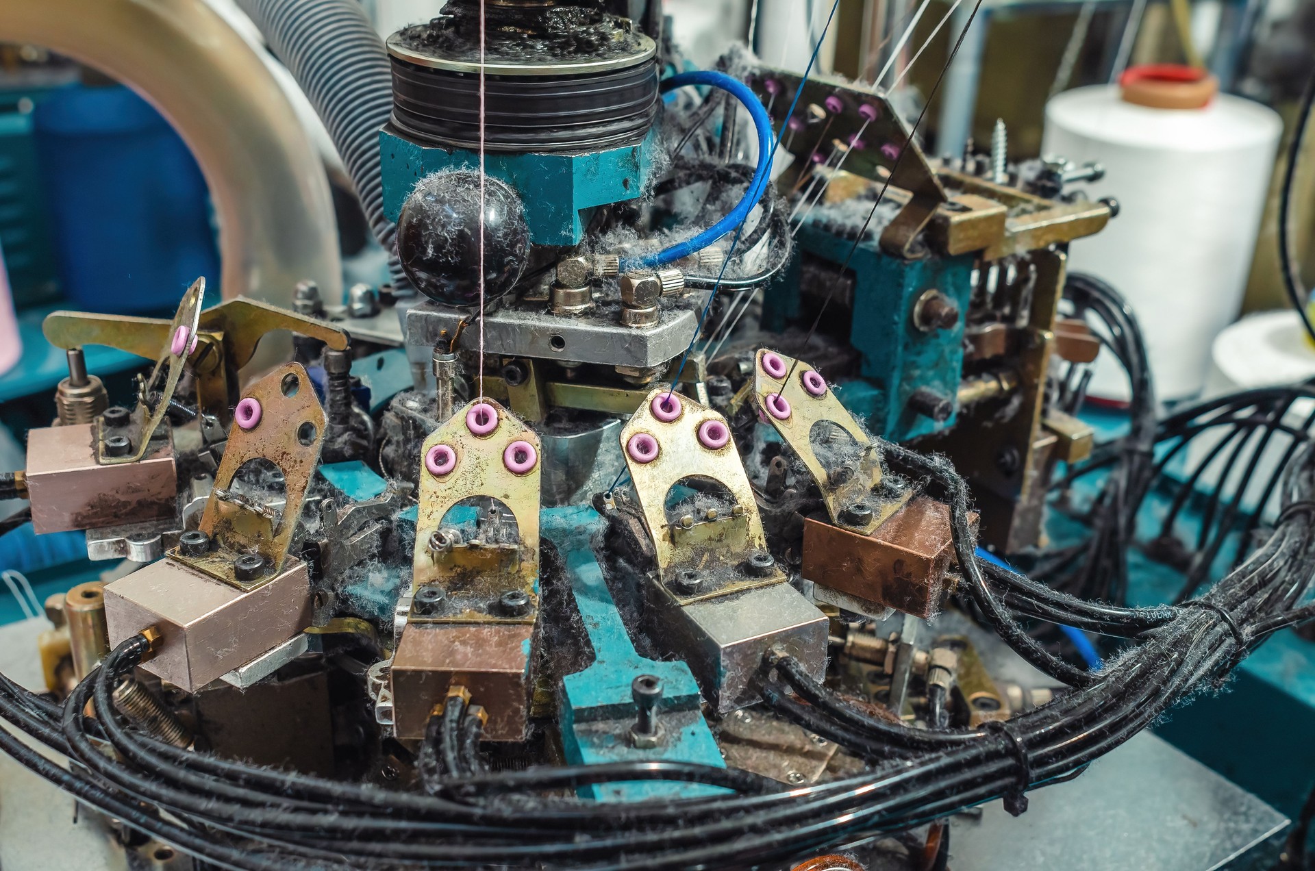 Dust from threads when making socks on knitting machine. Threads, parts, socks production.