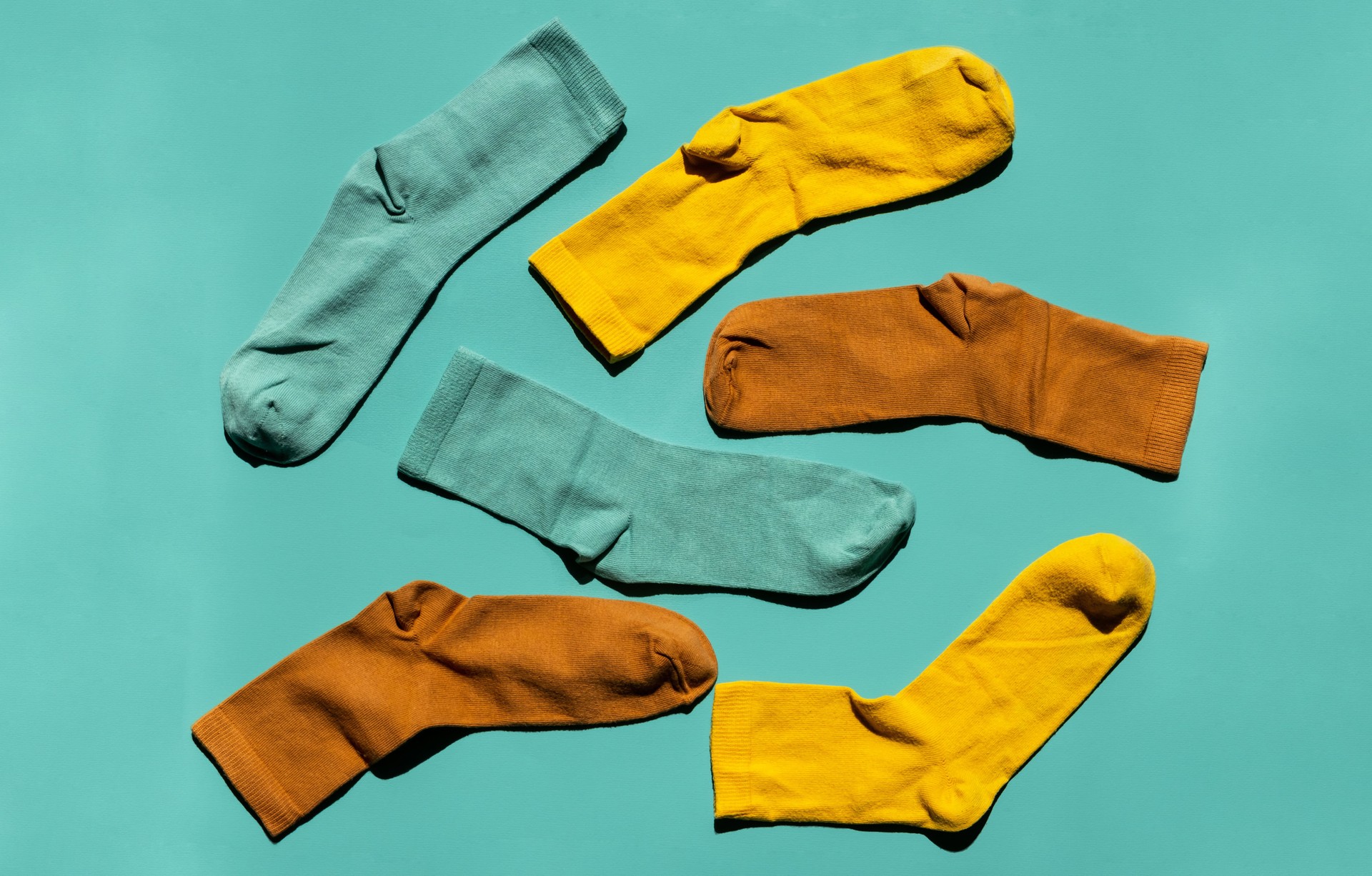 Some socks on turquoise background. Layout colourful socks.